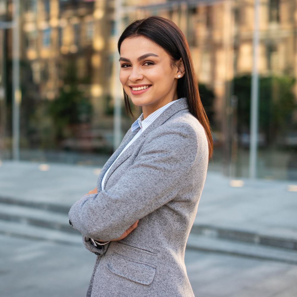 smiley-businesswoman-posing-outdoors-with-arms-crossed
